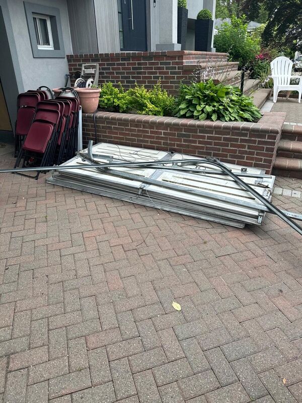 Old garage door sections and track laid on a paver driveway